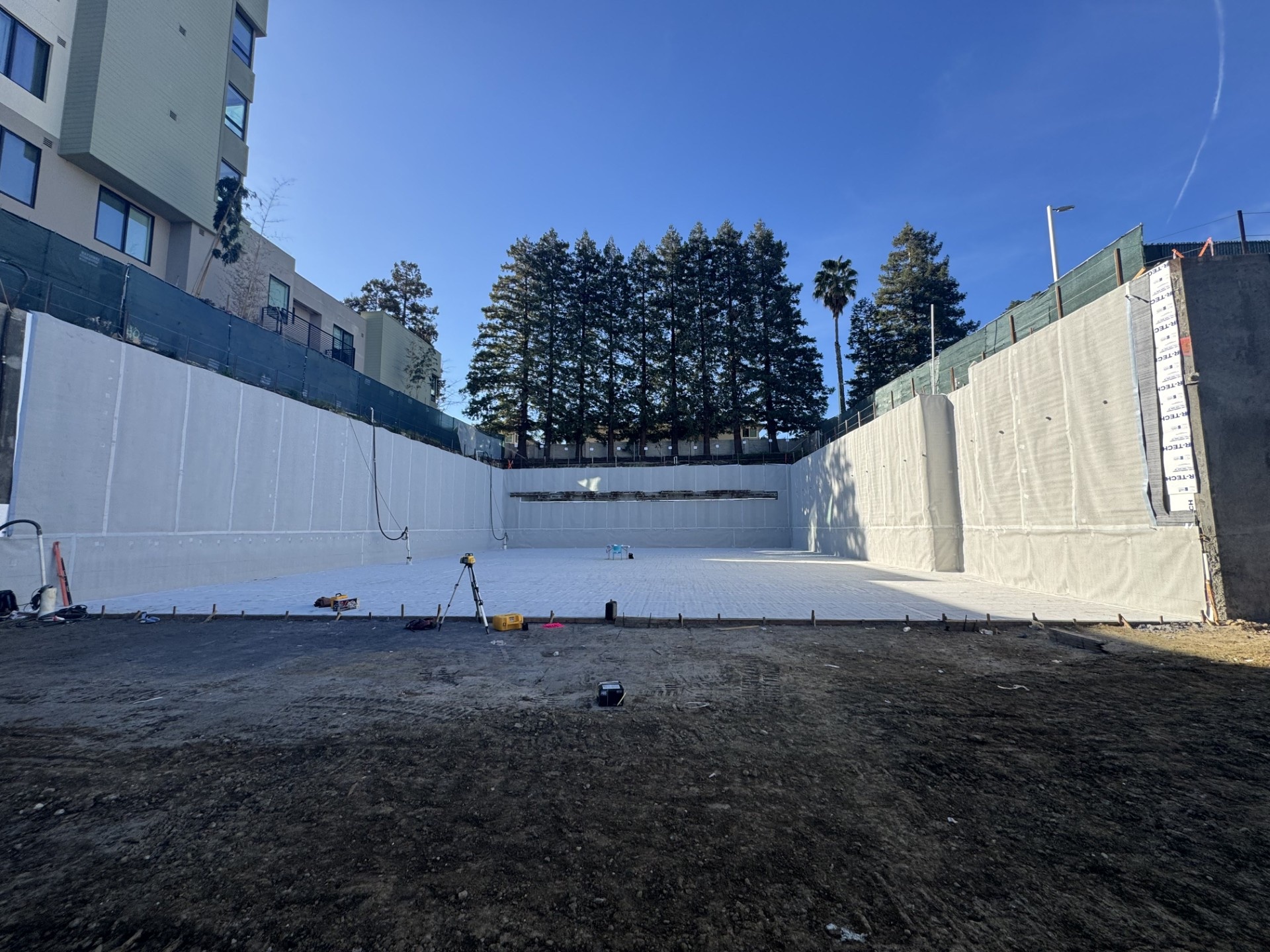 Vertical wall waterproofing application on retaining wall at construction site