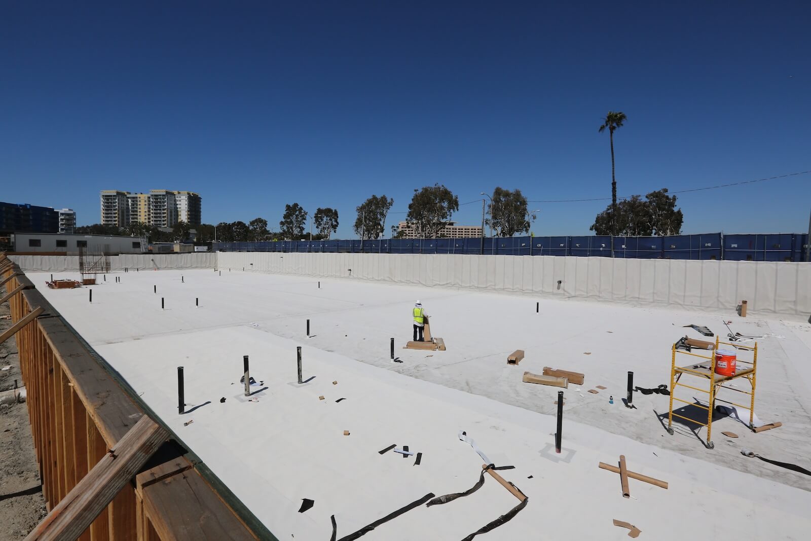 Workers preparing waterproofing system with penetrations and detailing in place