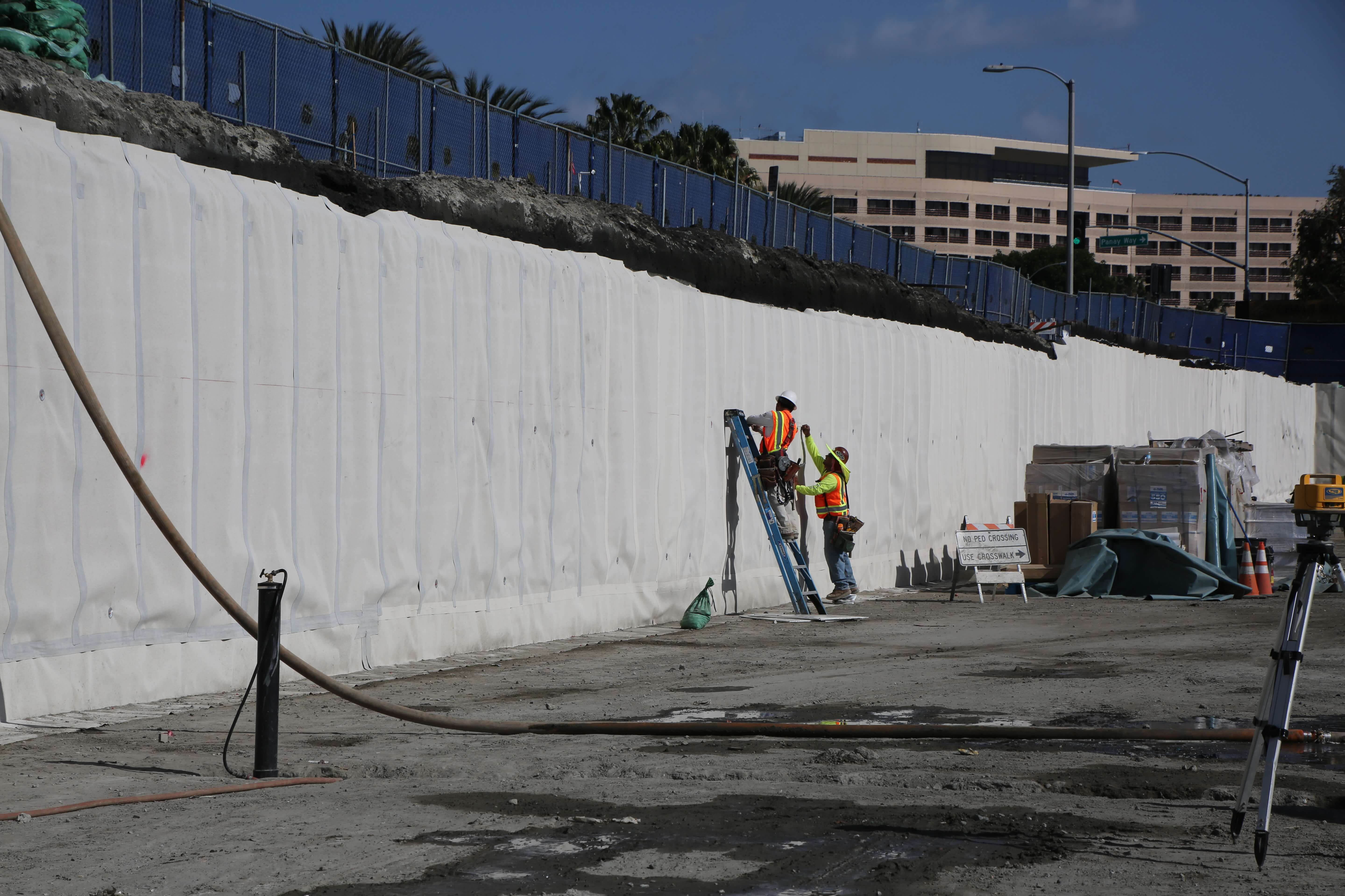 Vertical wall waterproofing application on retaining wall at construction site