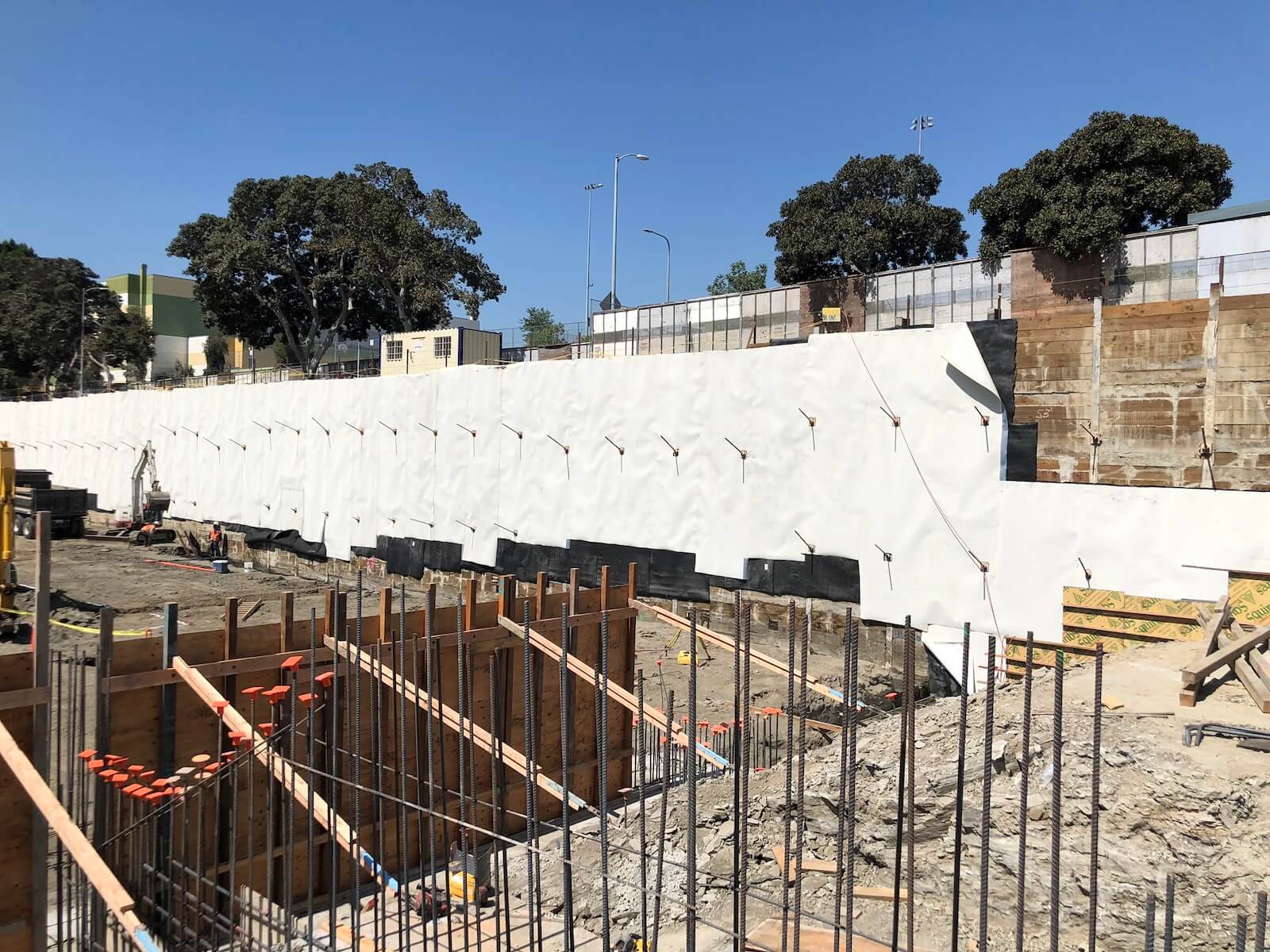 Aussie Skin 560G blindside waterproofing membrane applied to below-grade foundation wall