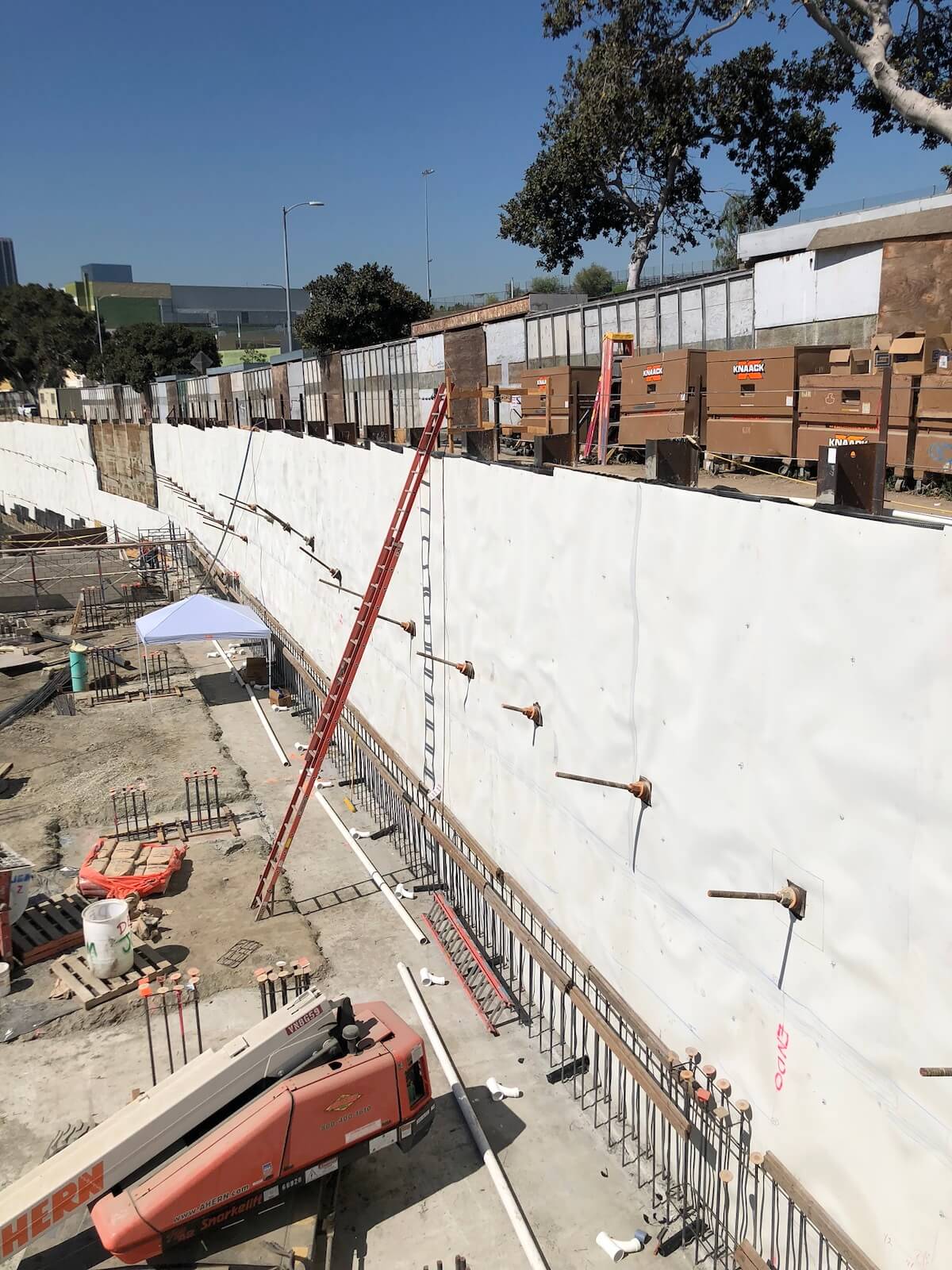 Blindside waterproofing membrane installed on deep foundation wall before concrete placement