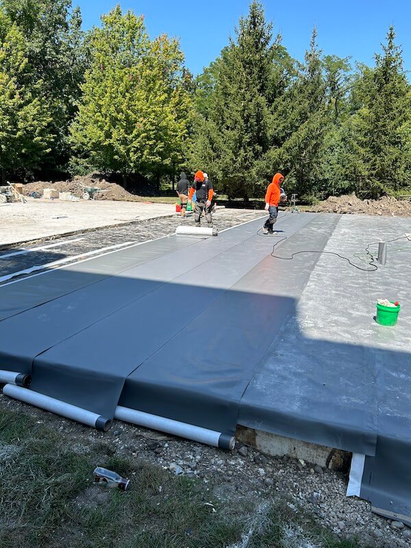 workers covering a foundation with Aussie Tite